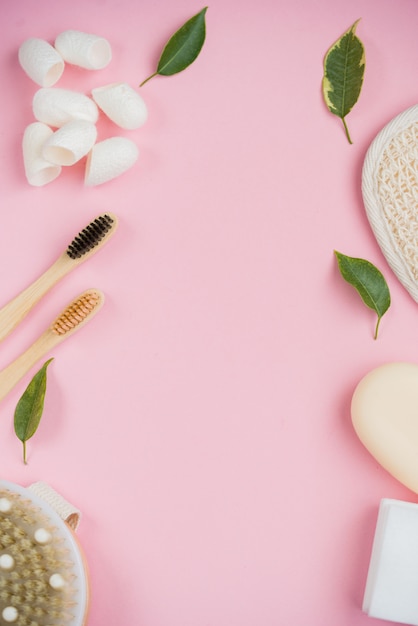 Cosmetic bath salt, grape gomaj for the face, coffee scrub for the body on a pink background.