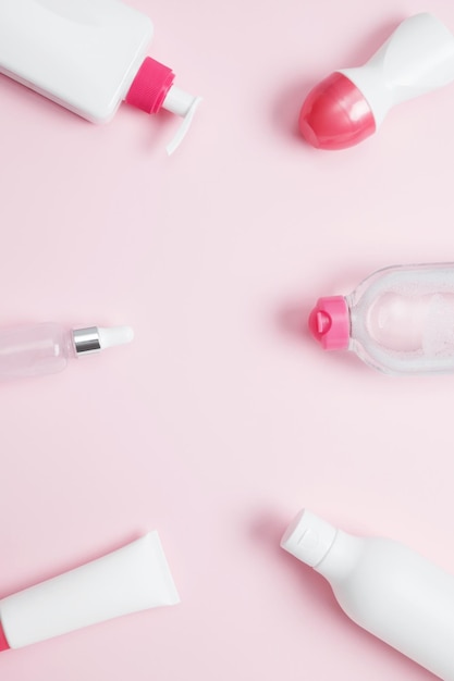 ピンクの背景の化 ⁇ 品 ブランド付きのボトルとチューブのモックアップ