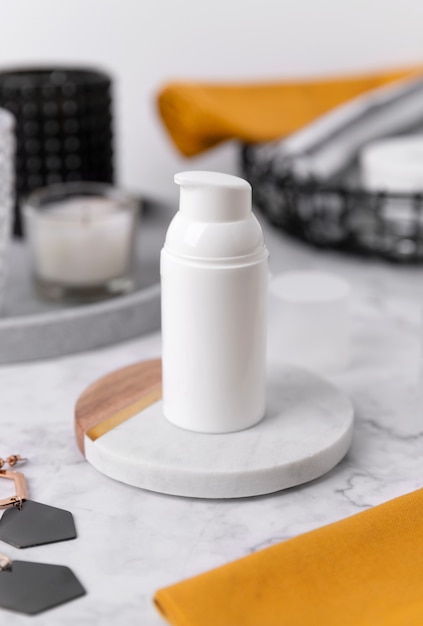 Cosmetic bottle containers with yellow towels and accessories on marble table