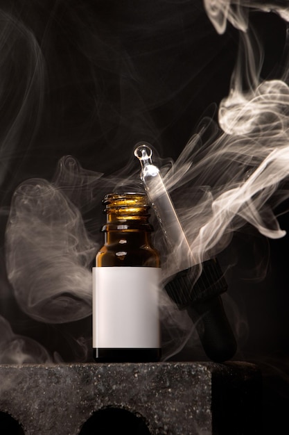 Cosmetic bottle mockup on a black background with smoke for oil