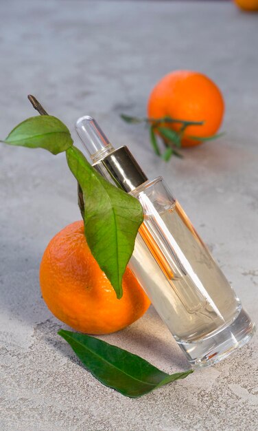 Cosmetic bottle, tangerines lie nearby