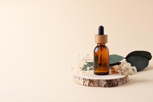 Cosmetic bottle with eucalyptus and wood on pastel beige background Close up copy space