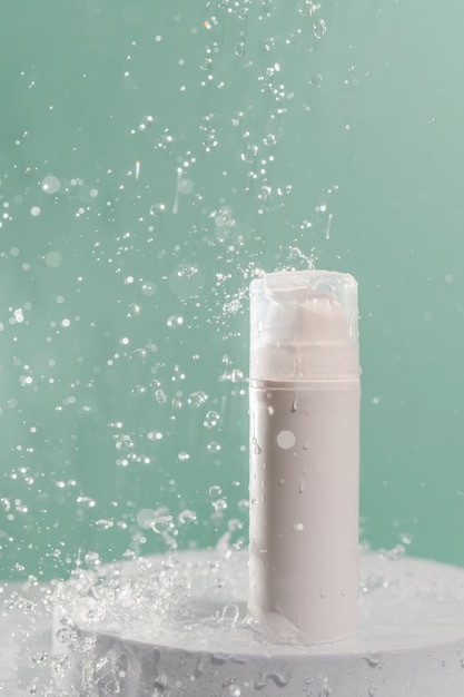 Cosmetic bottle with water splashes on a green background