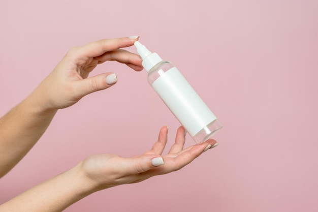 Cosmetic bottle in woman's hands Cosmetic product branding mockup Spa beauty treatment concept