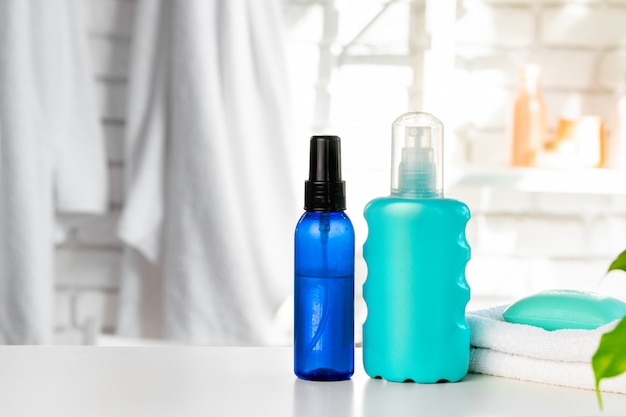 Cosmetic bottles against white bathroom wall background