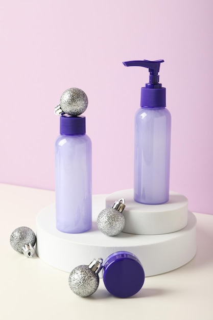 Cosmetic bottles and balls on purple background