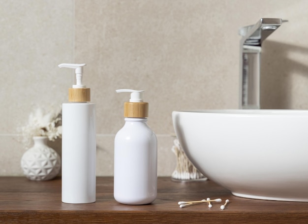 cosmetic bottles near basin on wooden countertop in bath mockup