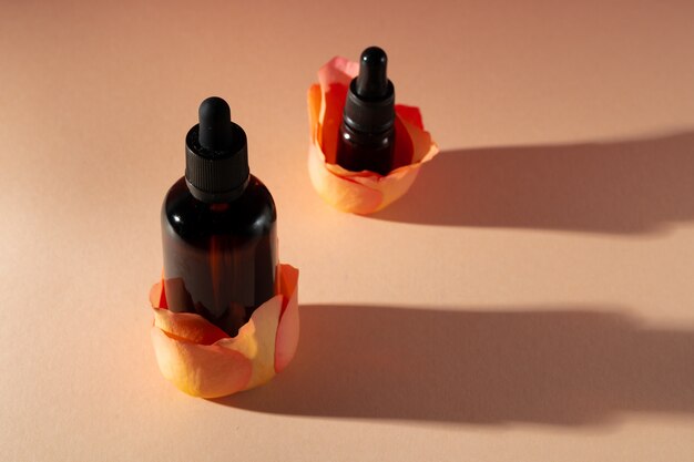 Cosmetic bottles with rose petals, copy space