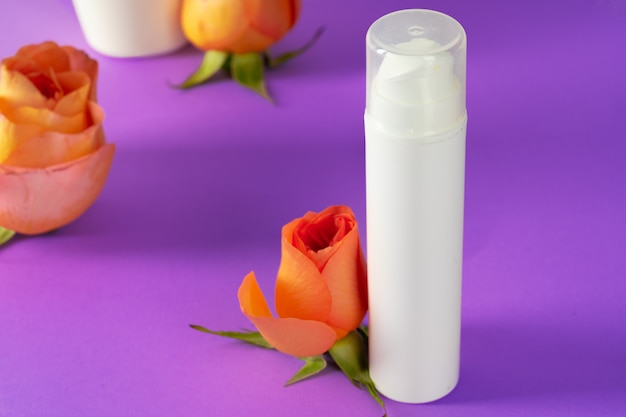 Cosmetic bottles with rose petals, copy space