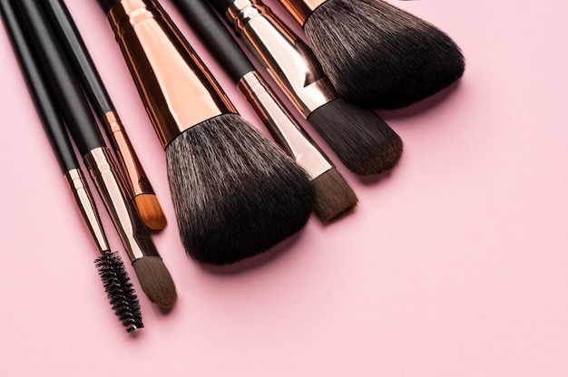 Cosmetic brushes of different sizes on pink