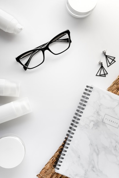 Фото Косметический крем, очки и планировщик на белом фоне. косметика по уходу за лицом увлажняющая концепция