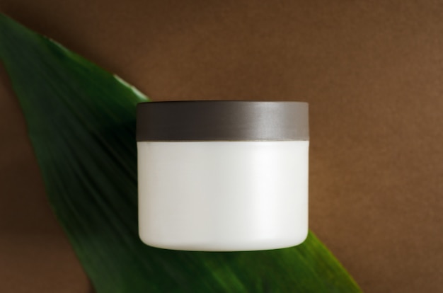 Photo cosmetic cream jar on leaf