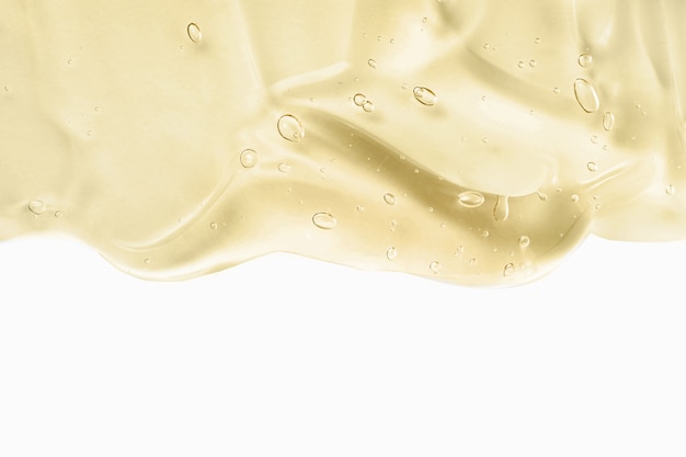 Cosmetic cream transparent liquid gel. Yellow gel smudge isolated on white wall. Skincare