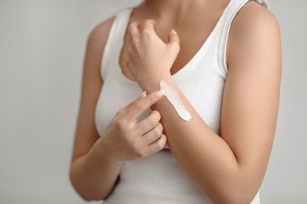 Cosmetic cream on the womens hand. Hand skin care. Woman applying protective cream.  Beauty and body care concept