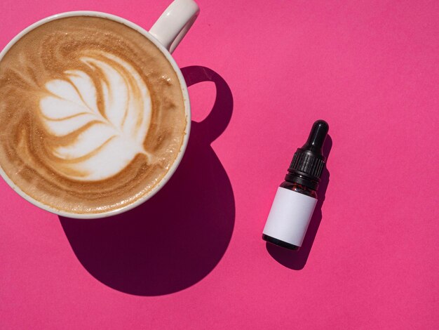 Cosmetic dropper bottle mockup with latte on pink background