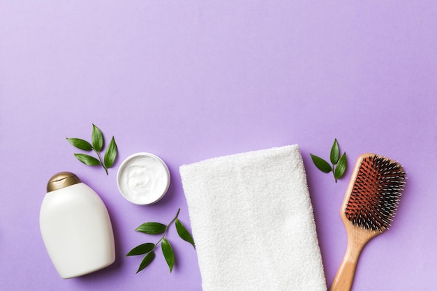 Cosmetic for hair care cream and towel on a colored background top view flat lay