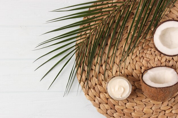 Cosmetic jars and coconut on the table closeup and place for text