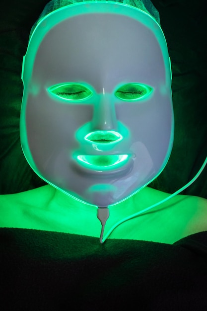 Cosmetic mask of light therapy on the patient face, burning green