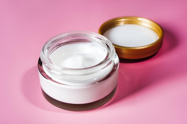 Photo cosmetic moisturizing anti wrinkle white cream in glass jar on pink background. high quality photo