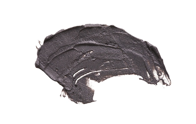白い背景で隔離の化粧品の泥マスク塗抹標本。上面図、黒い顔の粘土のクローズアップテクスチャ、コピースペース