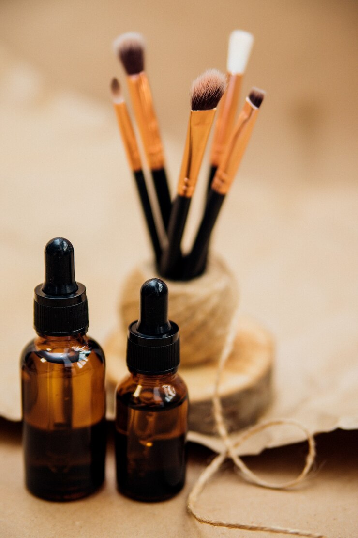 Photo cosmetic oil in a container with a pipette. makeup brushes stand on a podium made of sawn wood.