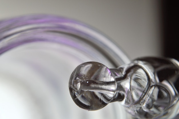 A cosmetic pipette filled with a bubbling liquid and a bottle. close-up.