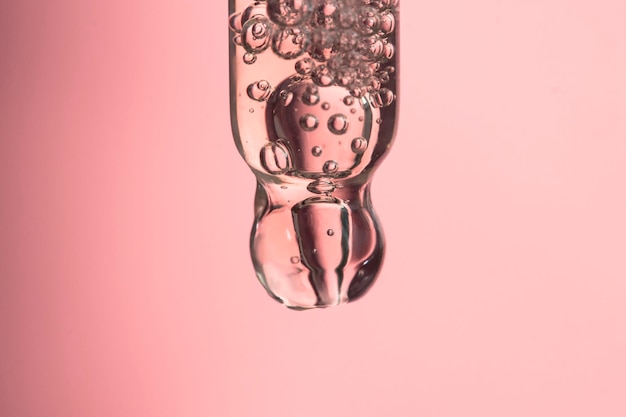 Косметическая пипетка с пузырьками внутри макроса Фон красоты со светлыми пятнами и средством по уходу