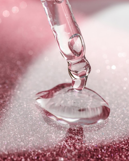 Cosmetic pipette with a pink on dark background