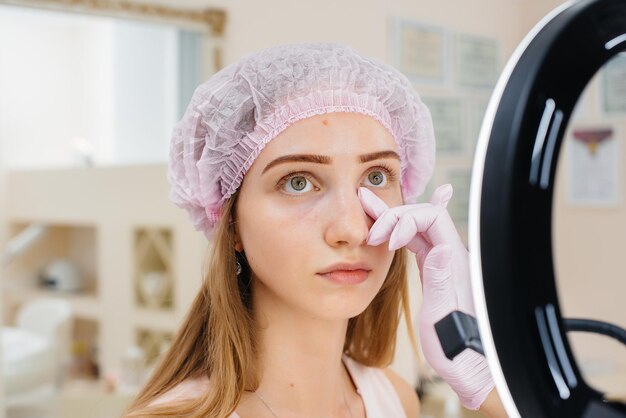 Cosmetic procedure for filling the nasolacrimal furrow and mesotherapy around the eyes for a young beautiful girl. Modern cosmetology.