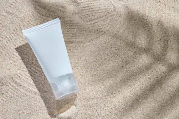 cosmetic product in tube on nature background with sand. Essential cream for moisturizing body skin