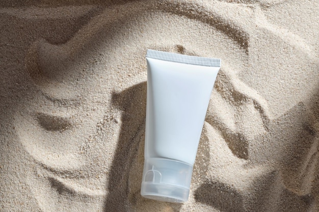 Cosmetic product in tube on nature background with sand\
essential cream for moisturizing body skin