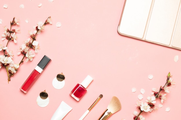 Foto prodotti cosmetici, orecchini, borsetta su uno sfondo rosa. vista piana, vista dall'alto