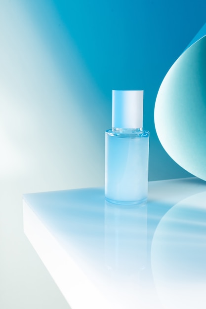 Photo cosmetic serum bottle on a white table, blue neon light, mock up