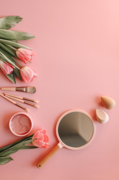 Cosmetic set top view flat lay on pink background