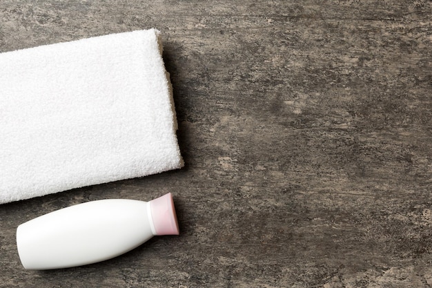Mockup di bottiglia di shampoo cosmetico con asciugamani su un tavolo colorato accessori per la toilette di sfondo del bagno per la cura delle mani e del corpo