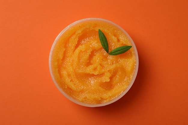 Photo cosmetic skin care scrub on orange