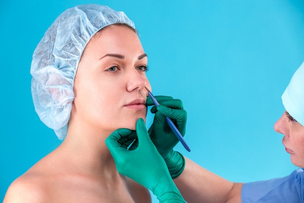 Cosmetic surgeon examining female client in office. Doctor checking woman's face