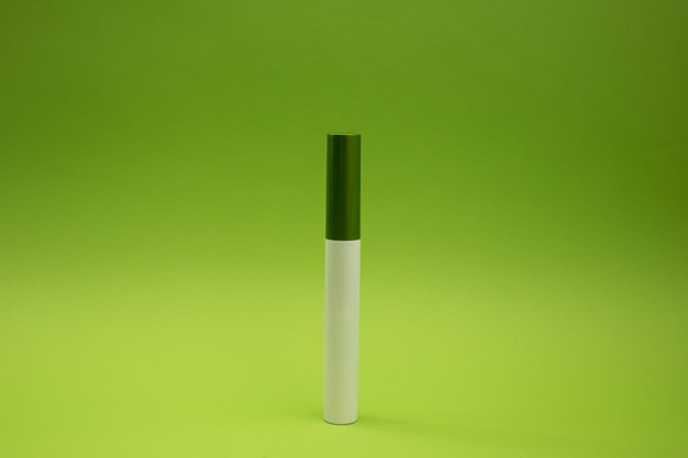 Косметическая трубка на зеленом фоне