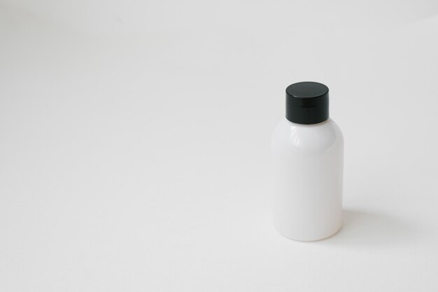 Cosmetic white bottle on white background. Cosmetic packaging for the collection of creams, oils, balms, shampoos. 