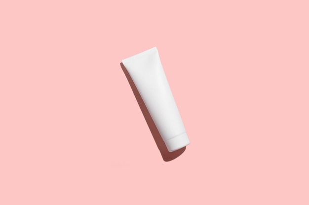 Photo cosmetic white plastic tube isolated on pink background mock up