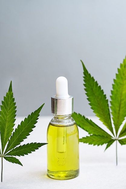 Cosmetica CBD-olie en bladeren van glazen cannabisflessen met hennepolie