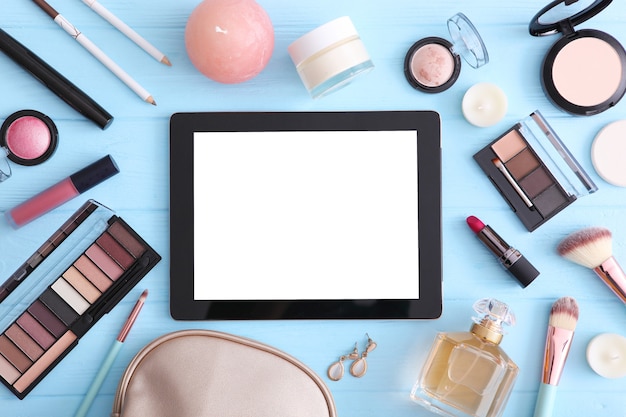 Cosmetica en moderne tablet op een gekleurde achtergrond bovenaanzicht