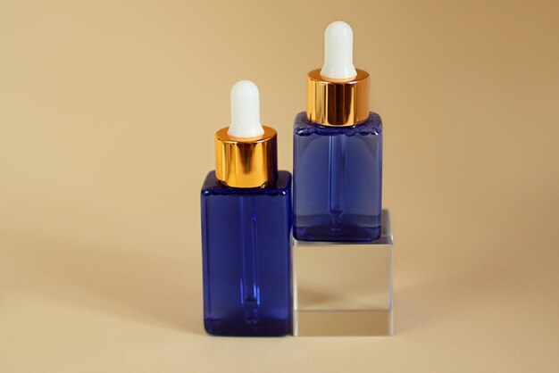 Cosmetica-flessen van blauw glas op het glazen podium Goed als mockup