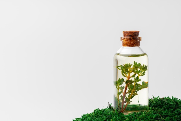Cosmetica in een flesje etherische olie op mos