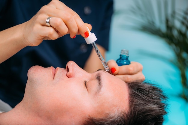 Cosmetician Applying Hyaluronic Acid Serum on Man's Face