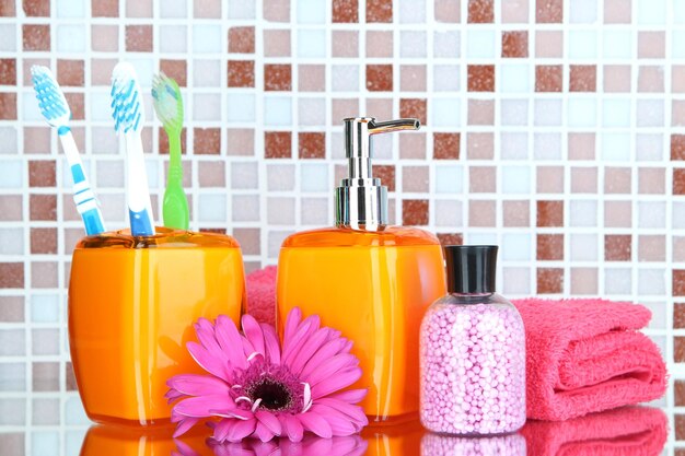 Cosmetics and bath accessories on mosaic tiles background