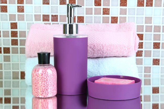 Photo cosmetics and bath accessories on mosaic tiles background