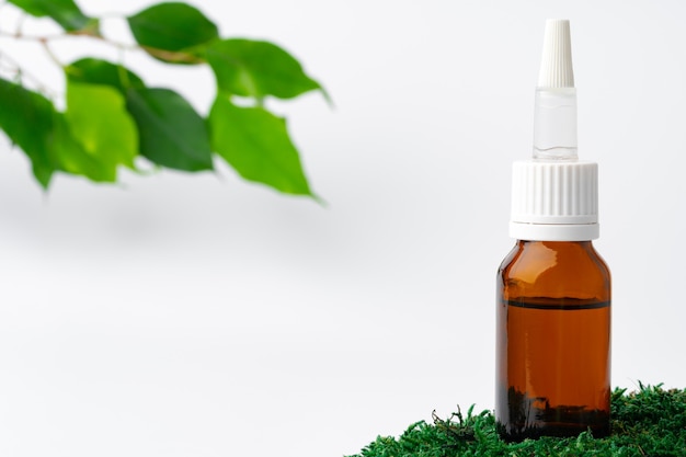 Cosmetics in a bottle essential oil on moss