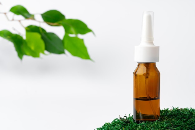 Cosmetics in a bottle essential oil on moss