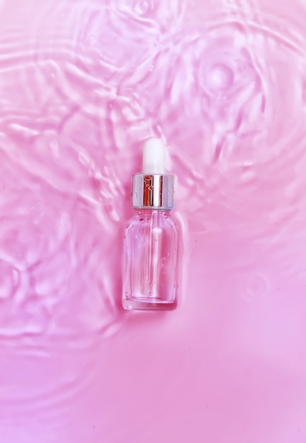 Cosmetics in a bottle in water, skin hydration concept. Hyaluronic acid. Selective focus.